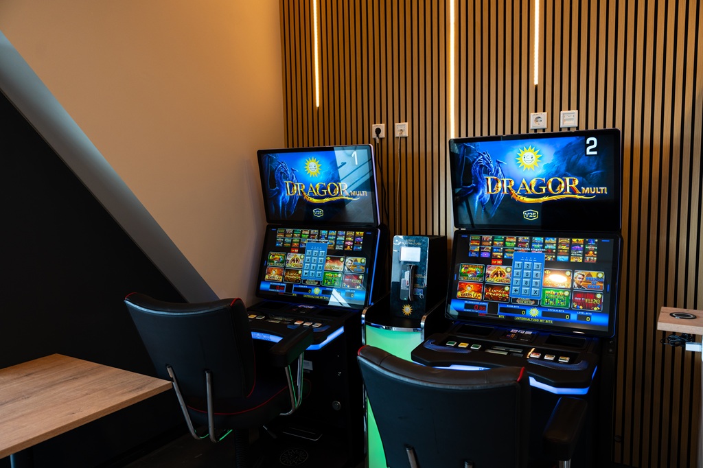 Zwei Spielautomaten im Spielbereich des Autohof Airport Hannover mit Sitzgelegenheiten und moderner Innenausstattung.