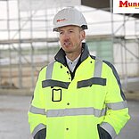 Arbeiter Mundt beim Bau des Autohofs in Arbeitsweste und Helm