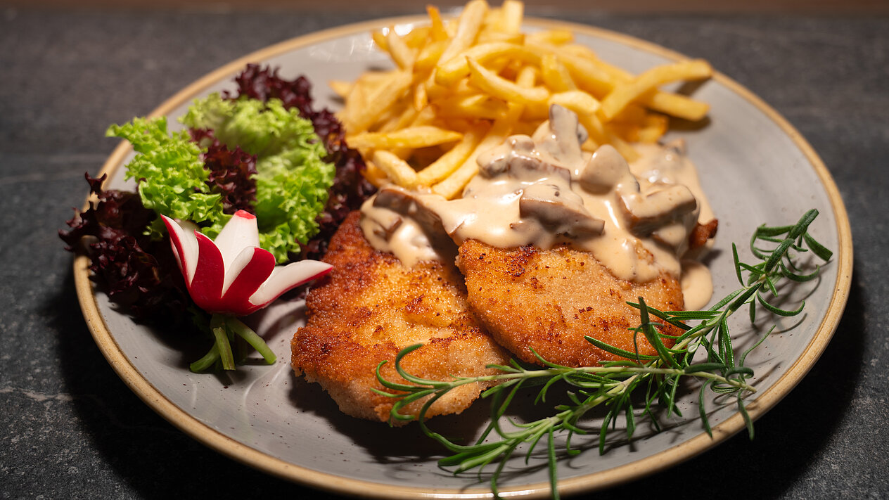 Leckeres Schnitzel mit Champignons und Pommes Frites