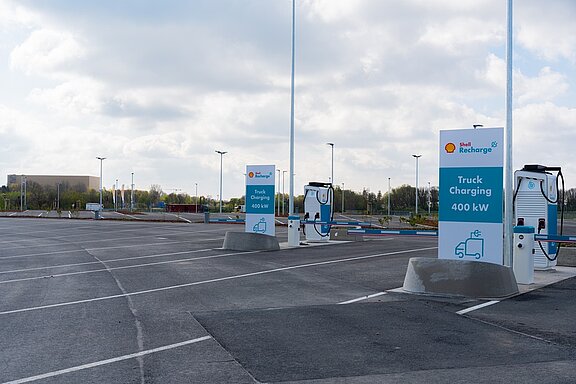 Shell Recharge-Ladestation für Lastwagen mit 400 kW in einem modernen Parkplatzbereich.