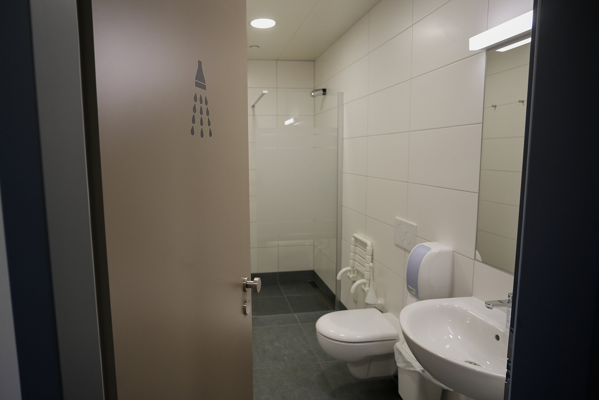 Blick in die einzelne Duschkabine. Ausgestattet mit einer modernen Walk in Dusche, sauberer Sanitäranlage und Waschtisch