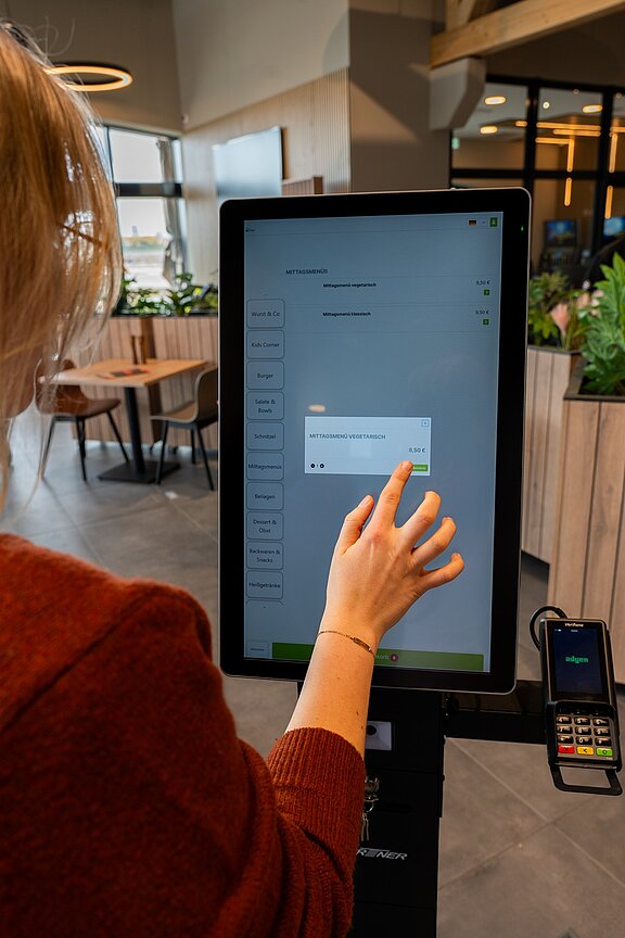 Ein Kunde nutzt eines der automatischen Bestellterminals.