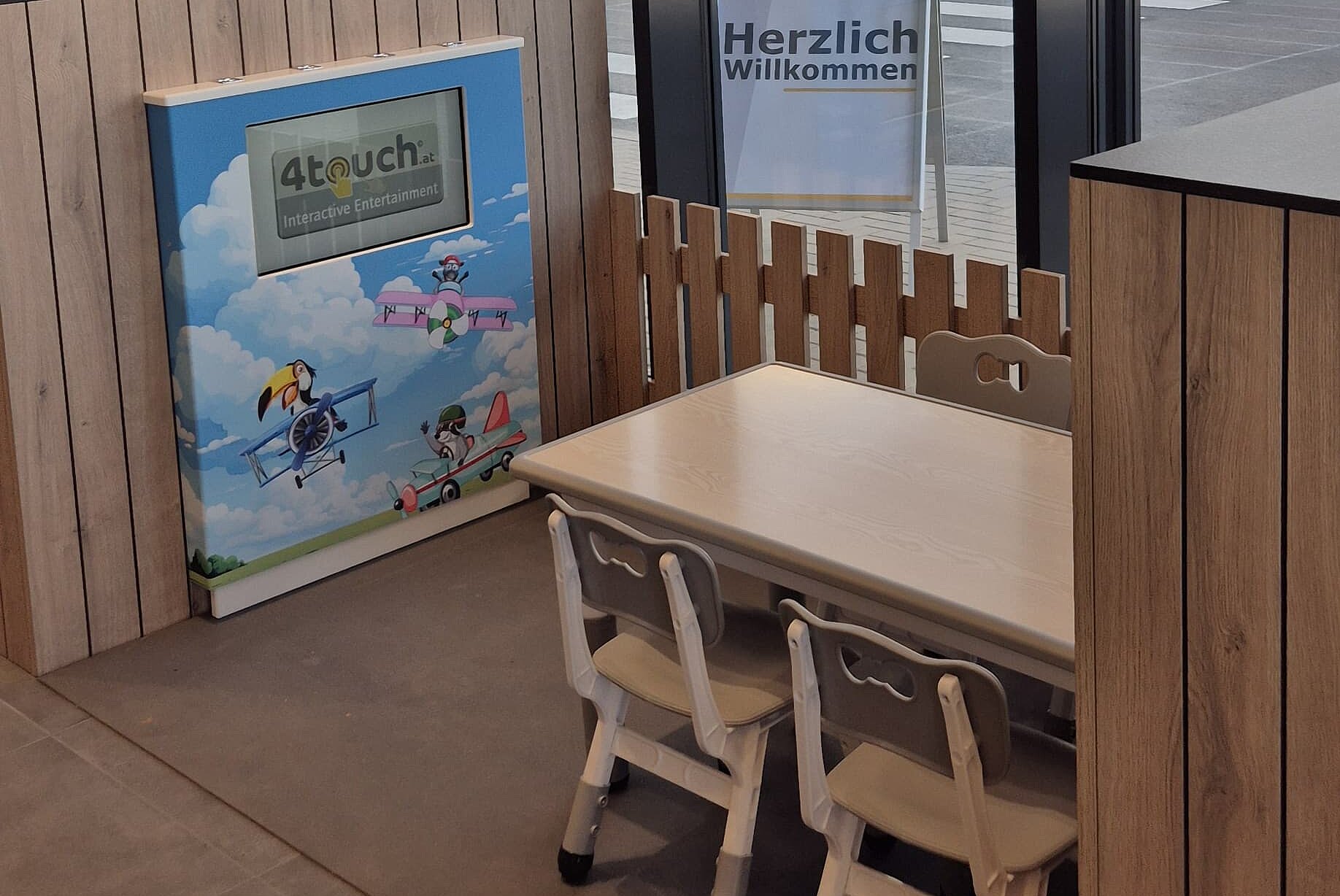 Kinder-Spieleecke mit Bildschirm, kleinen Tisch und Stühlen