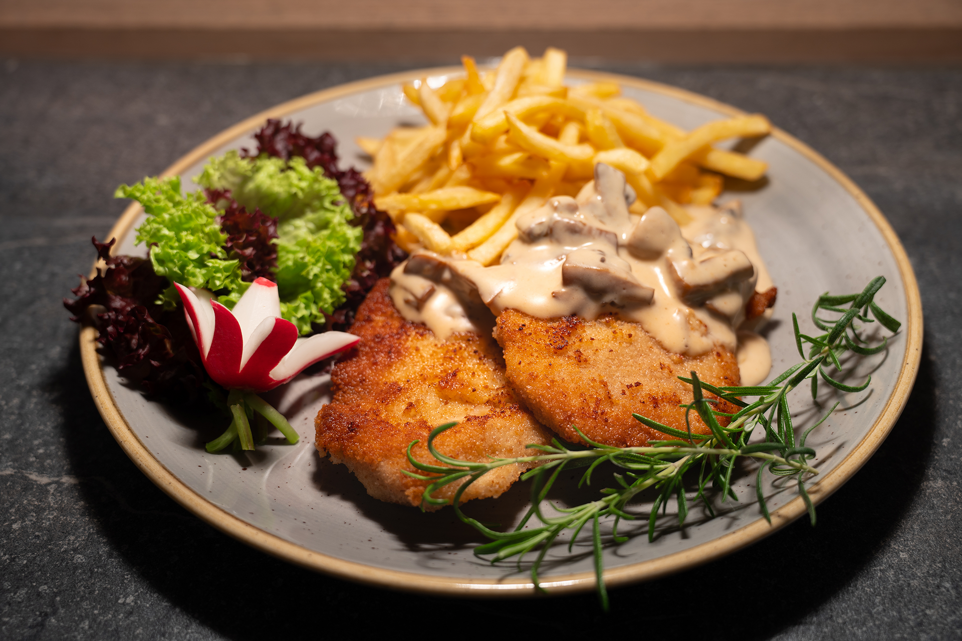 EIn saftiges Jägerschnitzel mit Jägersauce, Champignons und Pommes Frites